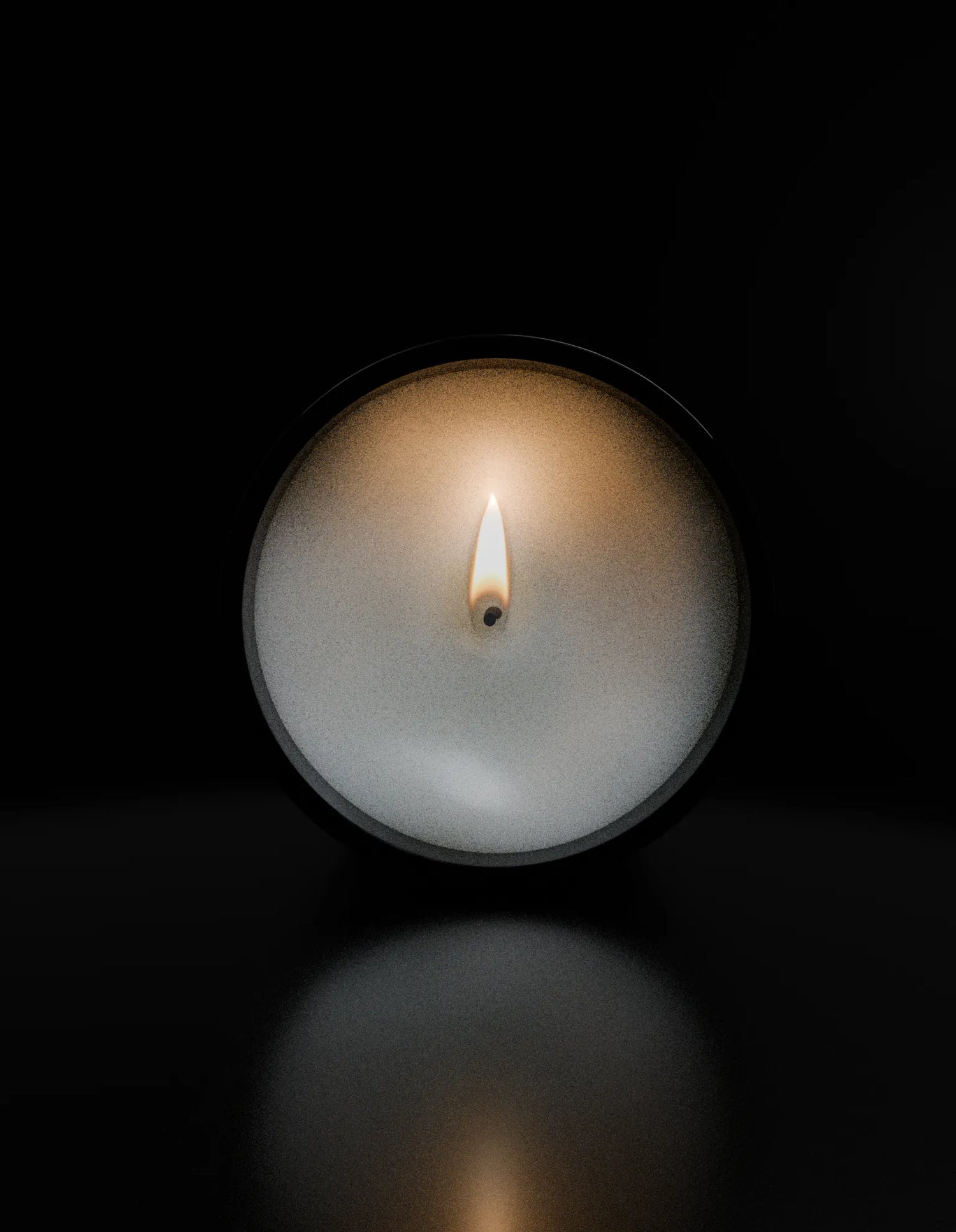 Top view of I’ll See You in My Dreams luxury scented candle by ōtéhà burning in black glass.